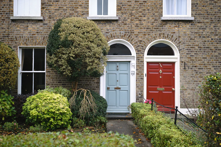 Front of a terraced house with red and blue doors in Sandymount, Dublin