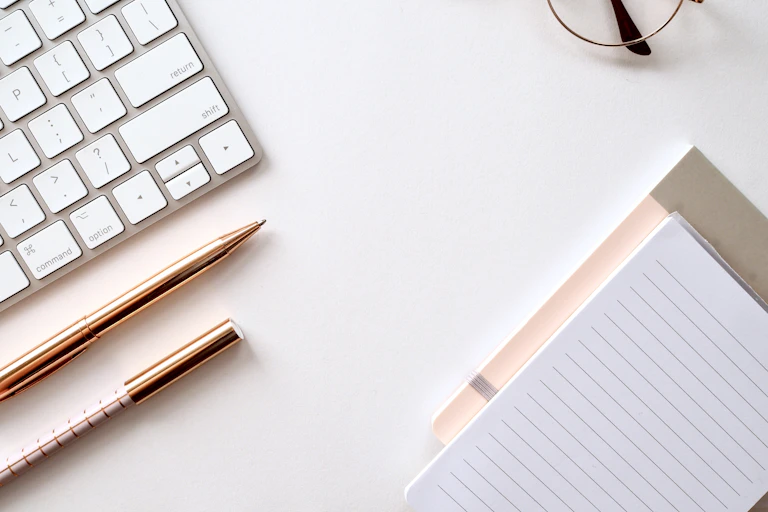 Pen, lined notebook and glasses on a desk ready for Leaving Cert revision