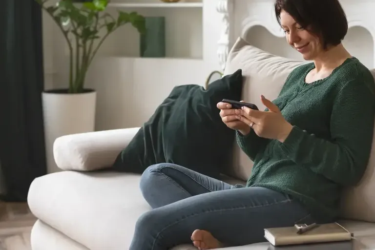 Woman sitting on a sofa looking at her phone